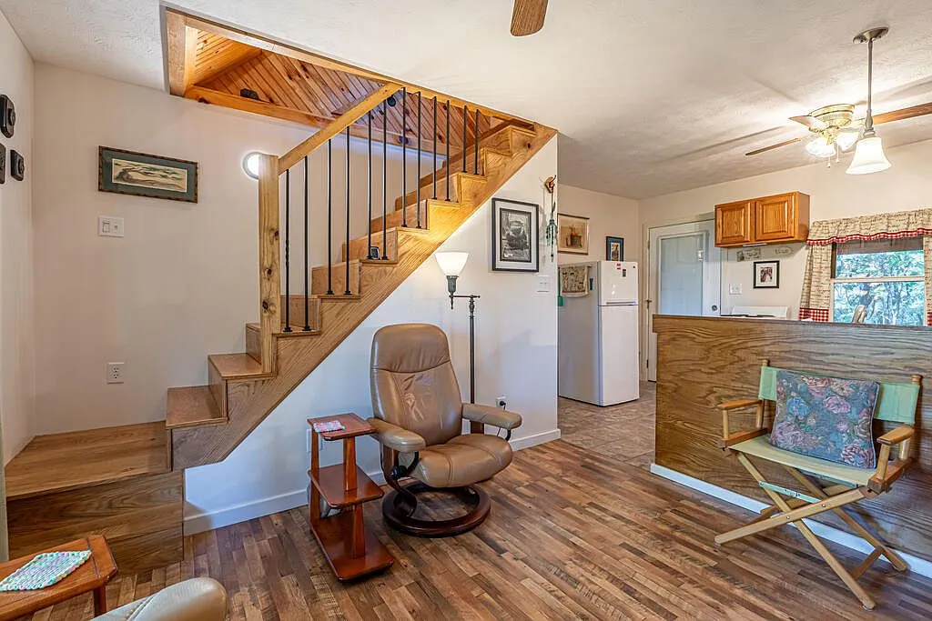 A second living room view showing the stairway and kitchen pass-through