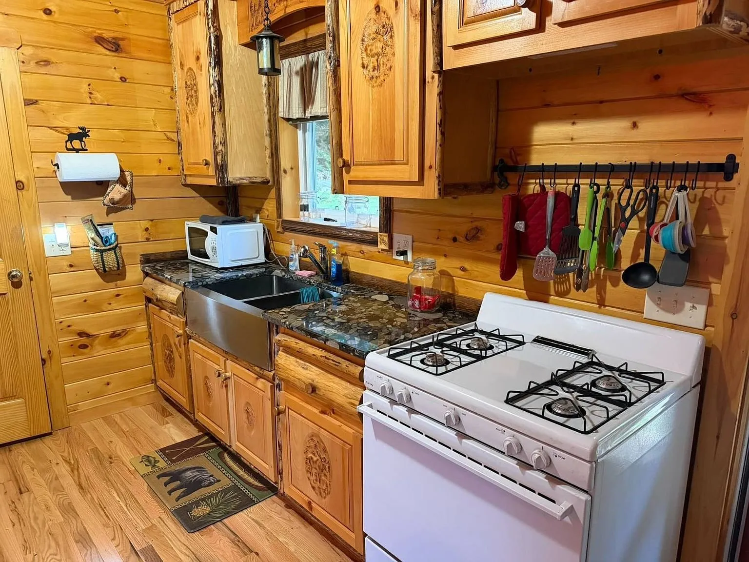 The kitchen with pine cabinets, the gas range and the sink