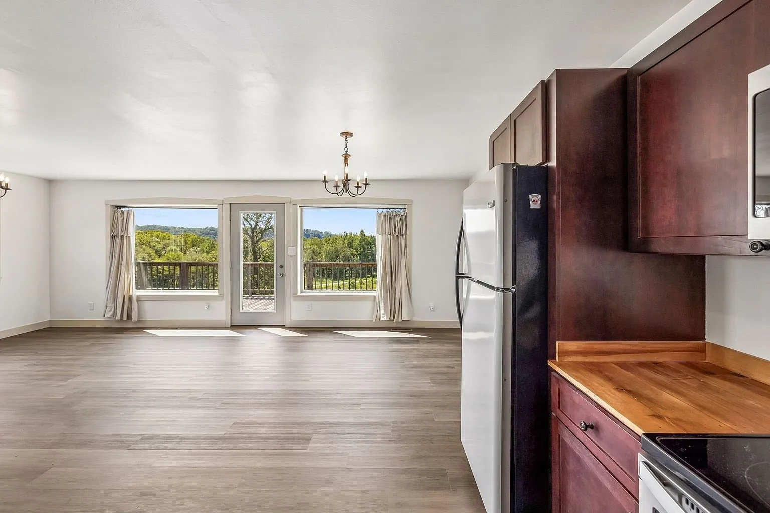 The main room toward the windows with the refrigerator at the right