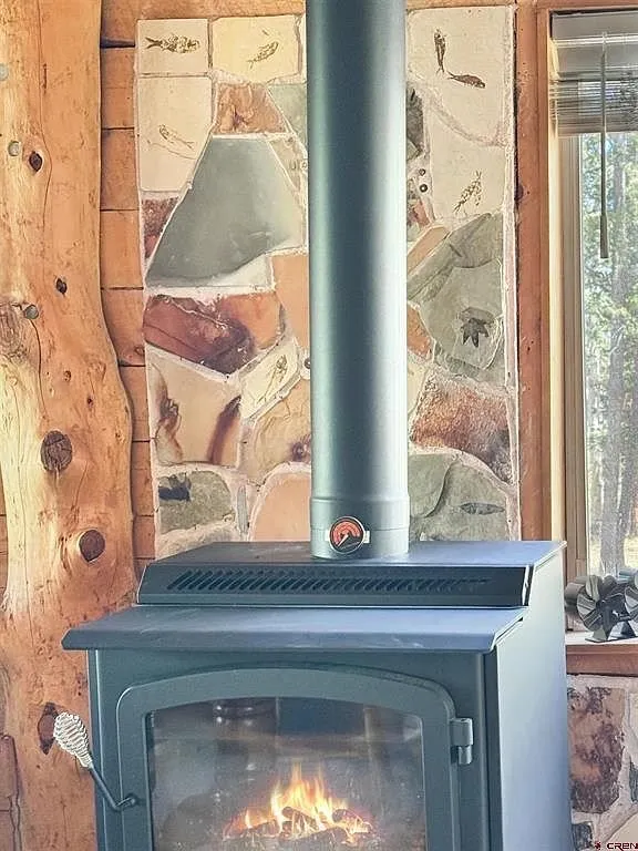 The wood stove on its stone hearth with the fire lit