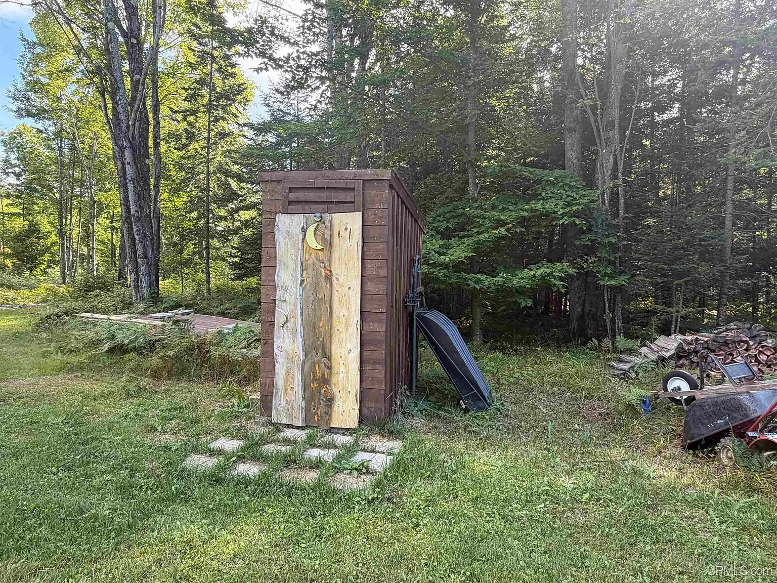 The outhouse at the edge of the yard