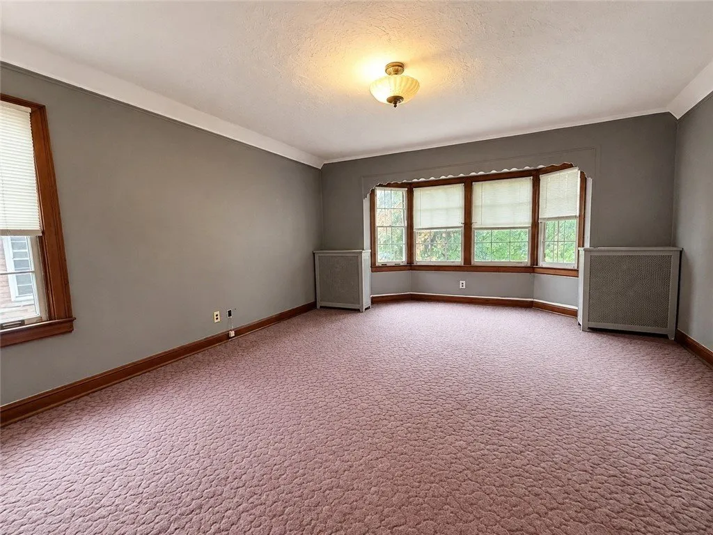 The same bedroom from the door with the bay and the carpet
