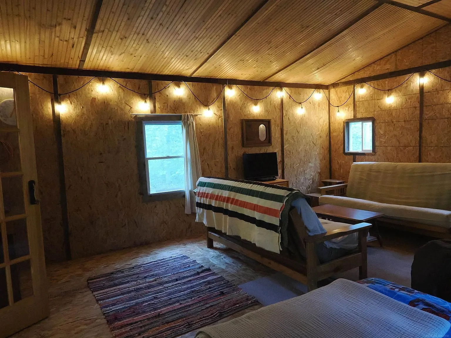 The futon by the window with the string lights