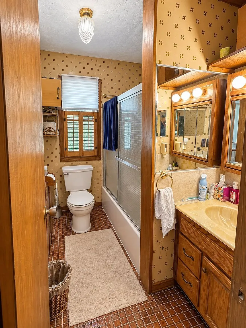 The bathroom with the toilet, the tub and shower and the vanity