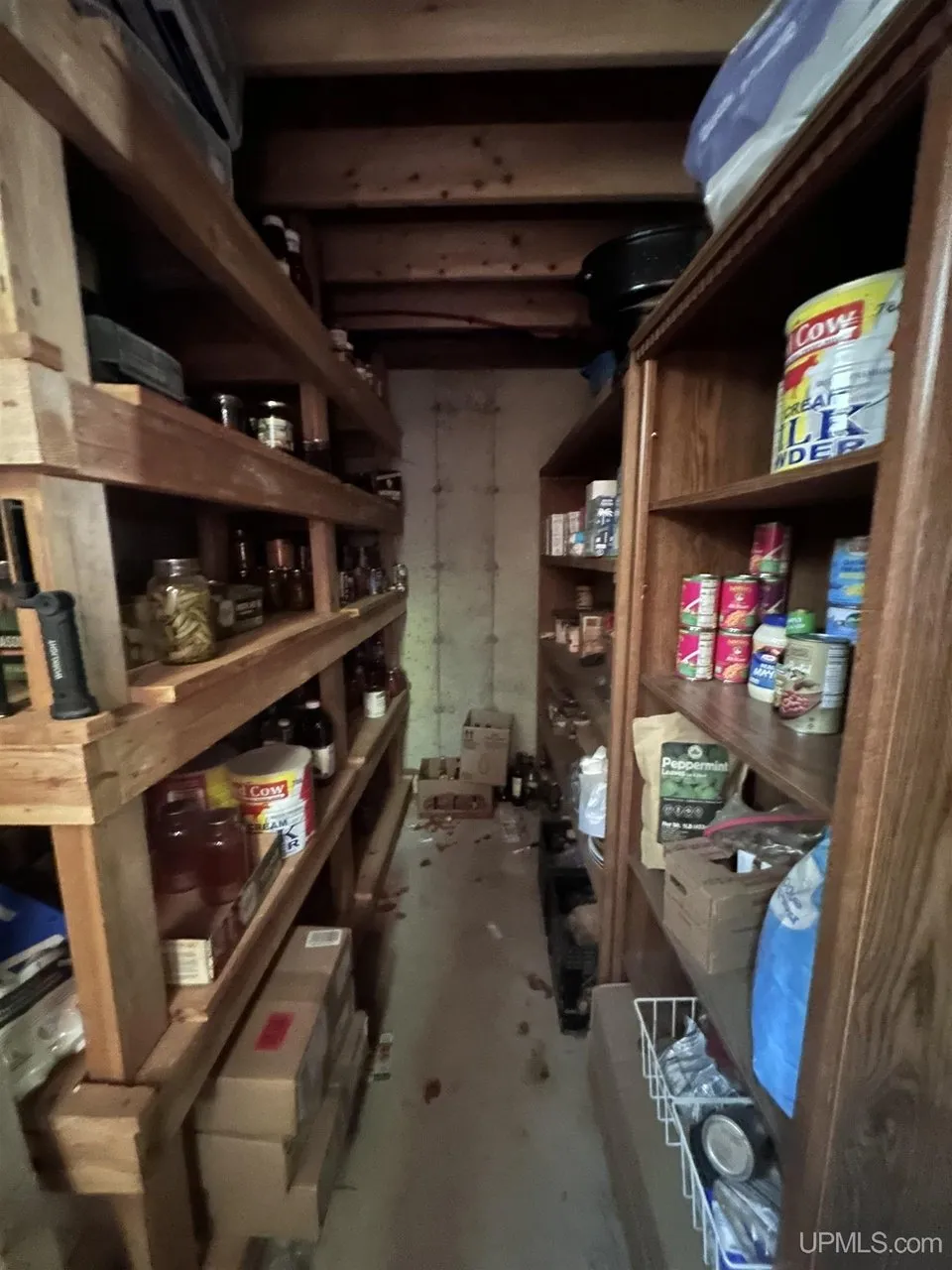 The pantry with wooden shelves of canned goods
