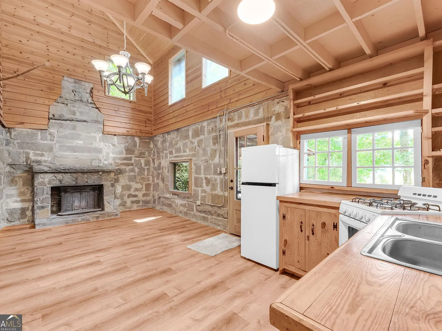 The dining area open to the kitchen, stone wall and vaulted ceiling above
