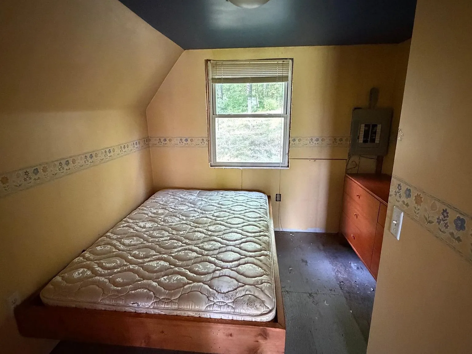 The bedroom with the mattress on the floor under the window