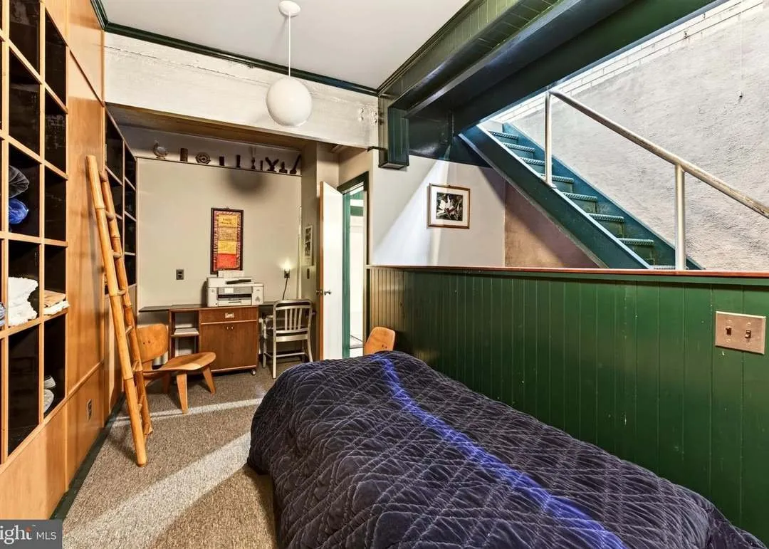 The lower-level bedroom with a bed set against built-in wood shelving