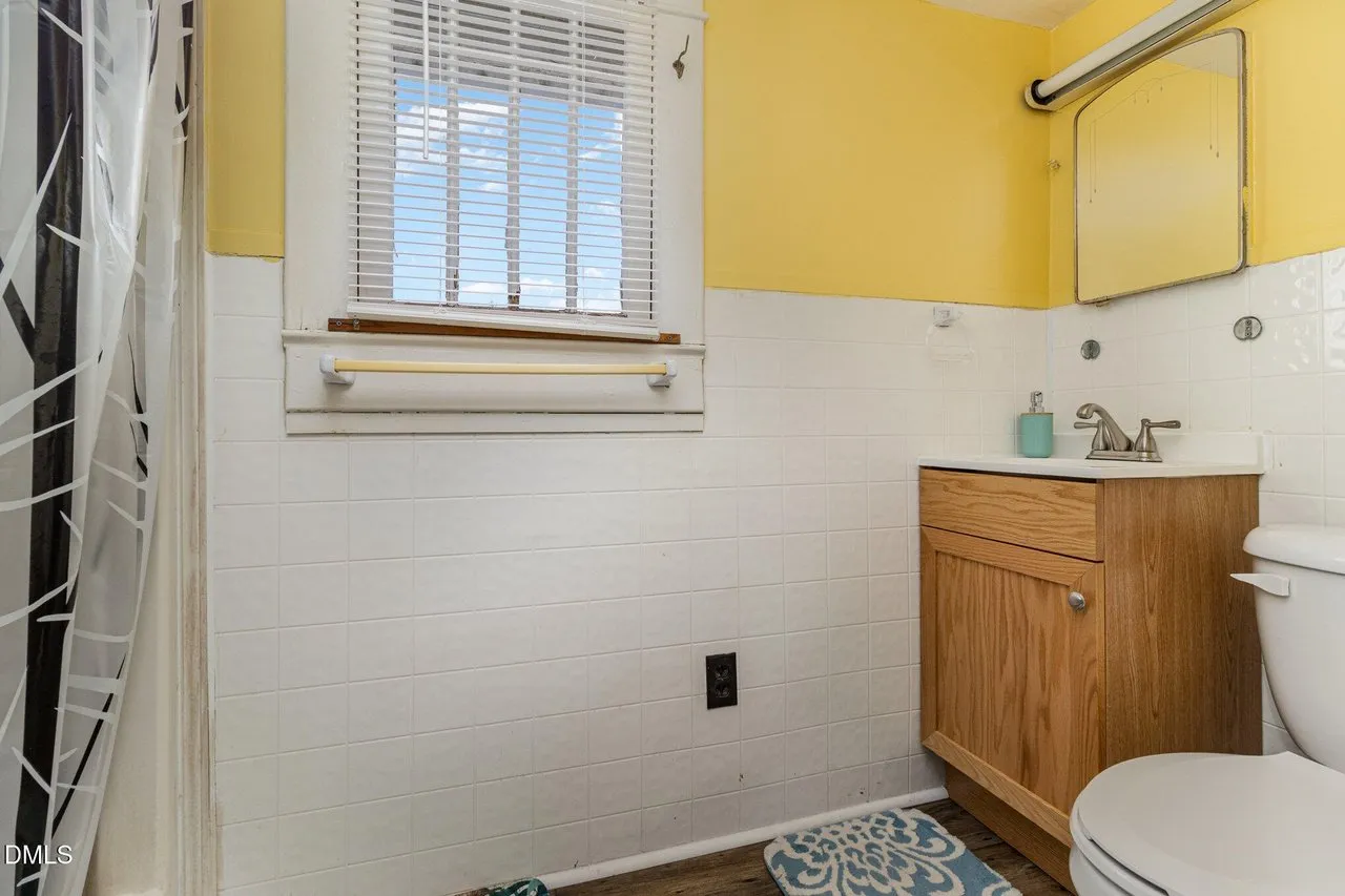 Second bathroom with yellow walls and a wood vanity