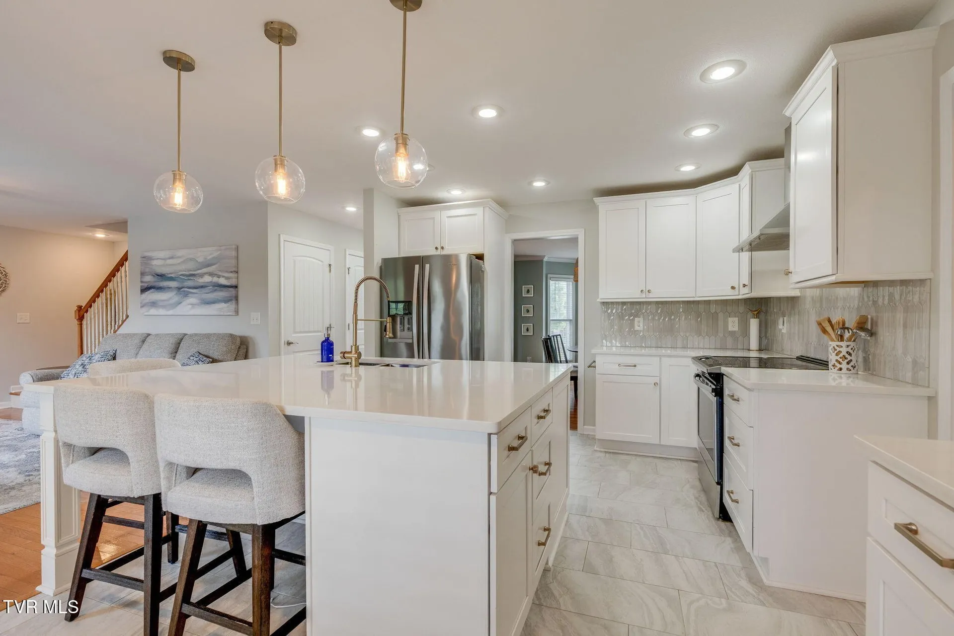 The kitchen from the breakfast area with the island and bar stools