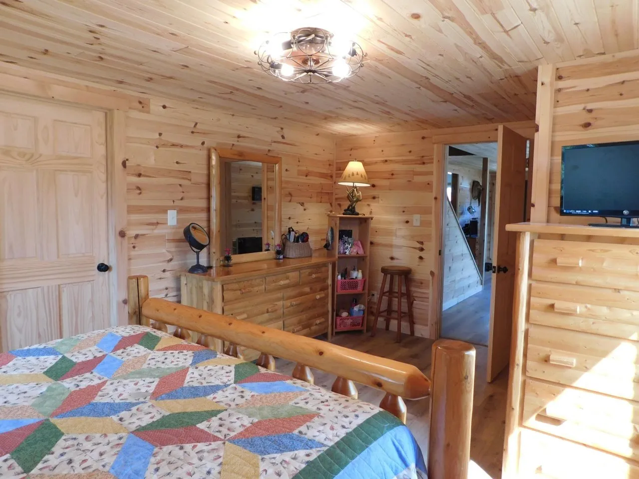 The main floor bedroom with a log bed frame and quilt