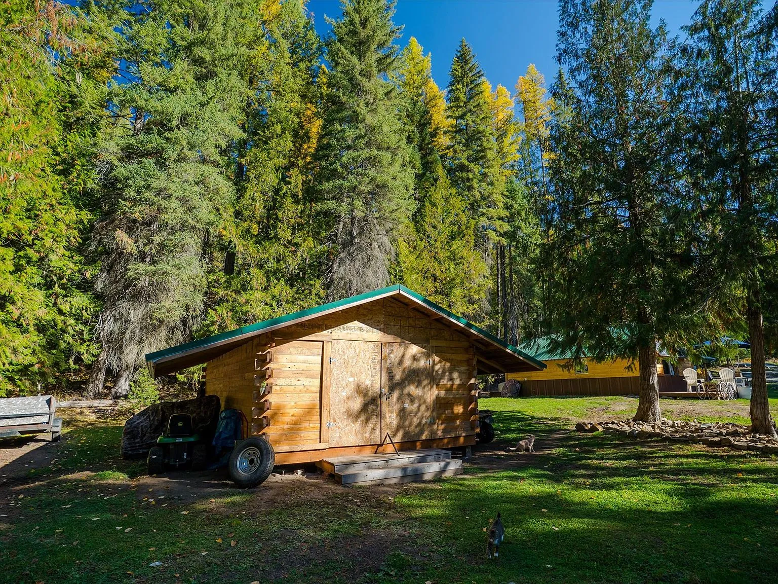 The RV parked on a gravel pad near the tree line