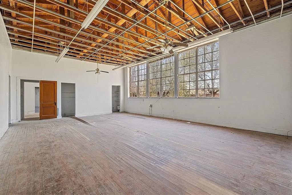 A classroom with the joists exposed and the windows along one wall