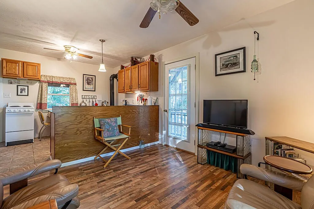 The kitchen and living area with a wood stove, TV and leather seating
