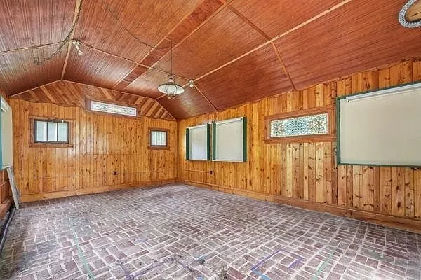 A room with the log walls, the windows and the paver floor