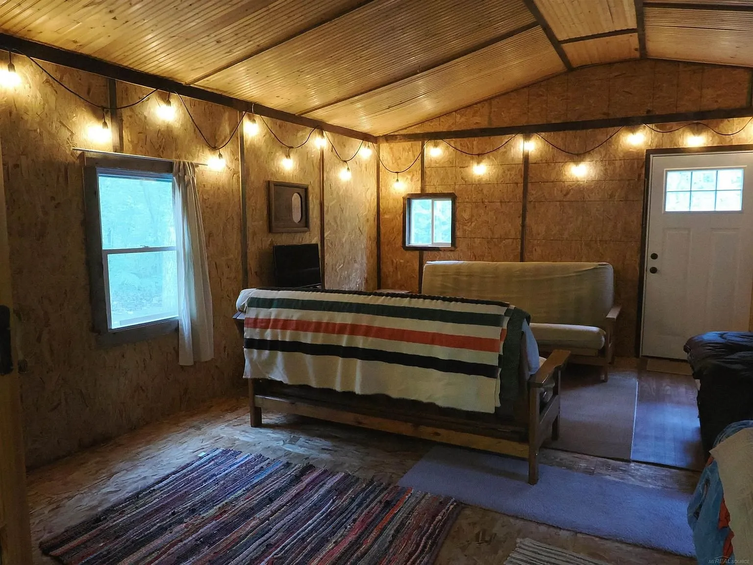 The futon and the rug in the common room with the door