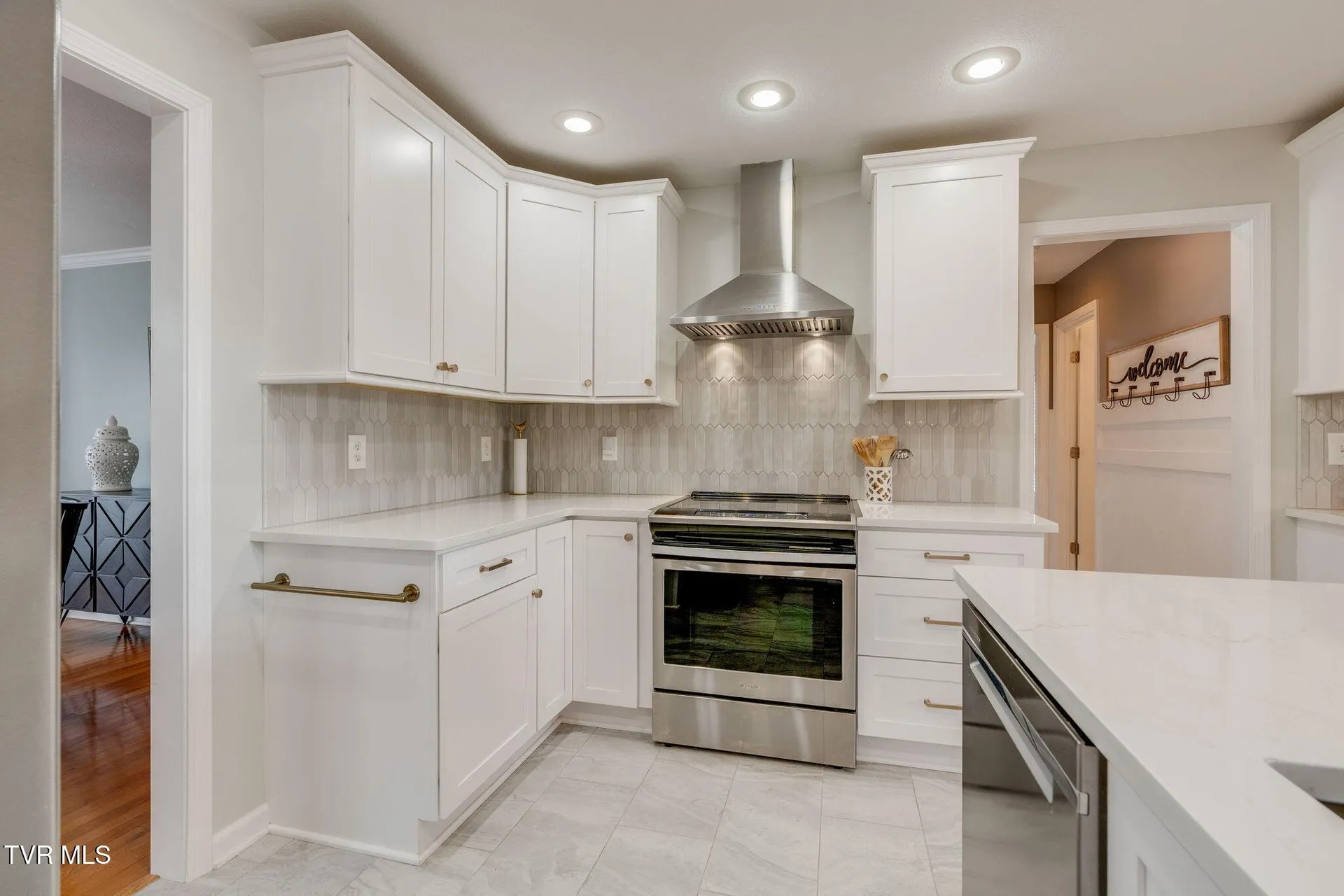 The range with its vent hood between white upper cabinets
