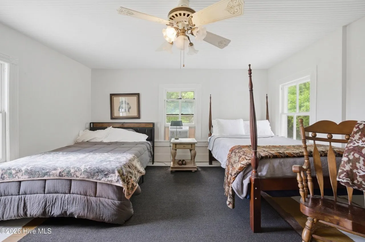 Bedroom with two beds and a ceiling fan, carpeted