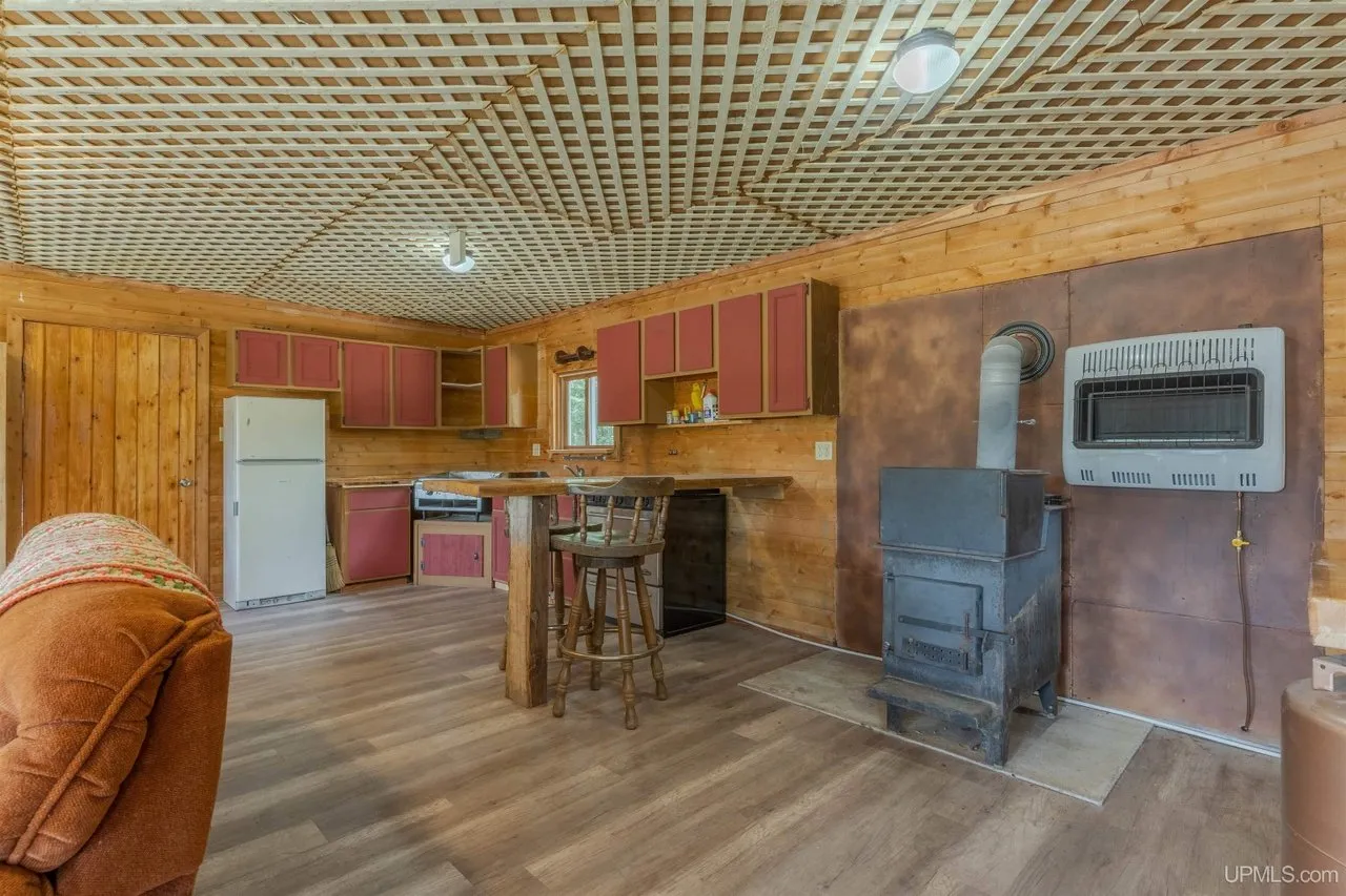 The wood stove in the corner beside the kitchen cabinets