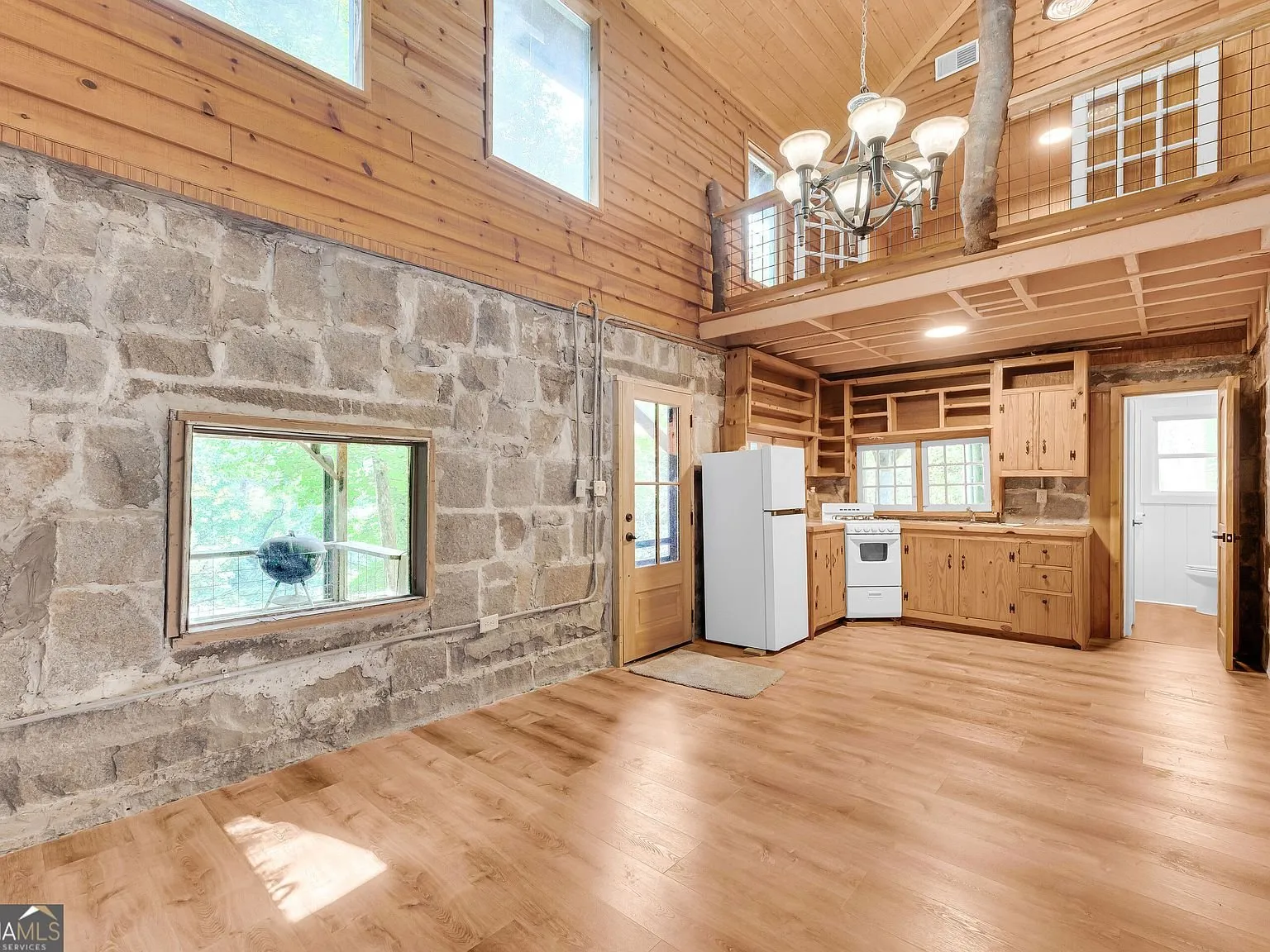 A hallway with stone walls leading toward the bedrooms