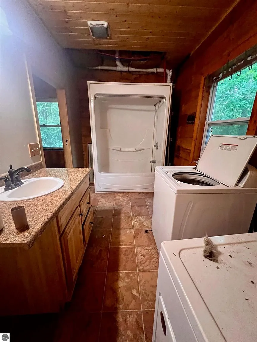 The laundry from the doorway with the washer and the vanity