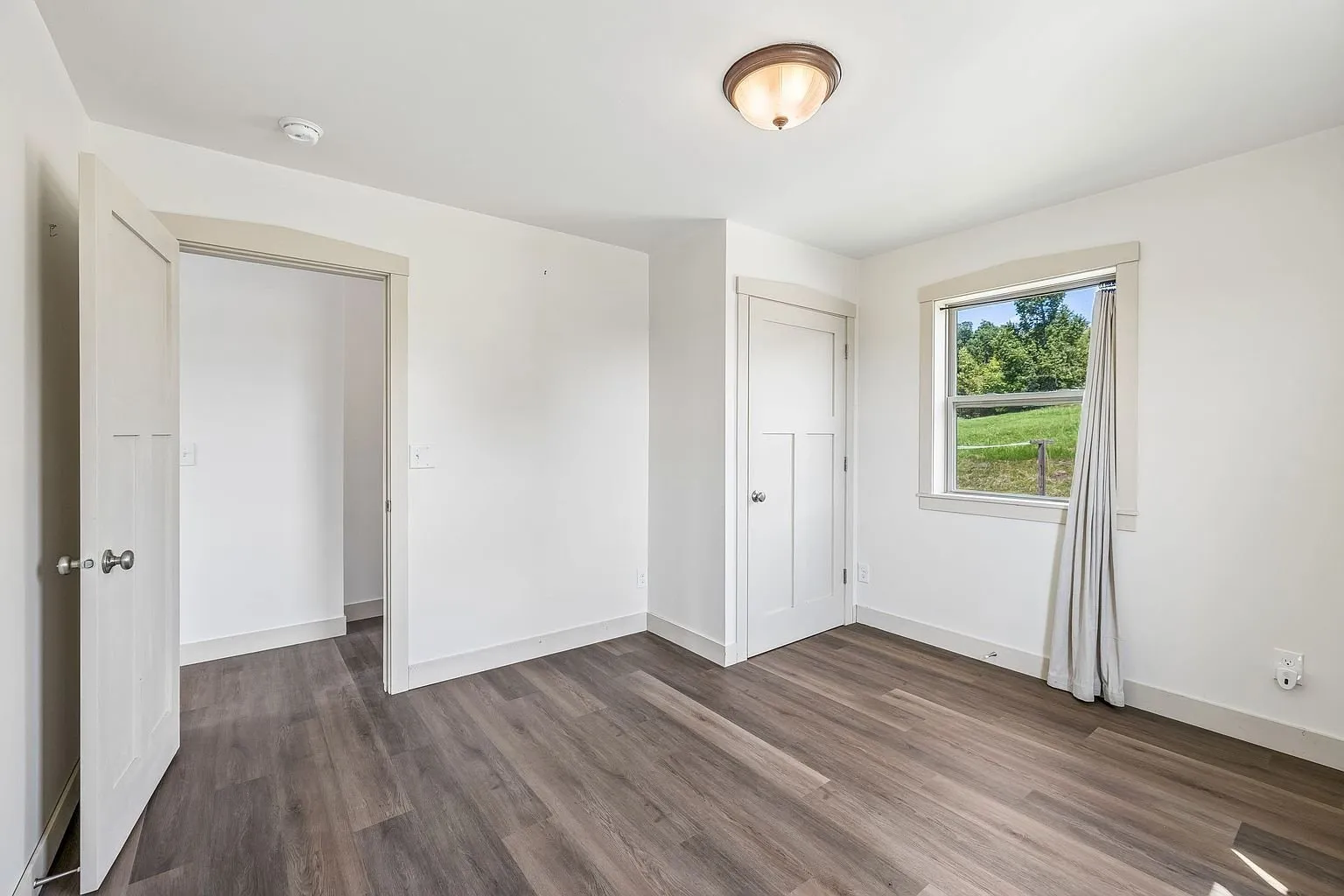 The hall with the closet doors and the window