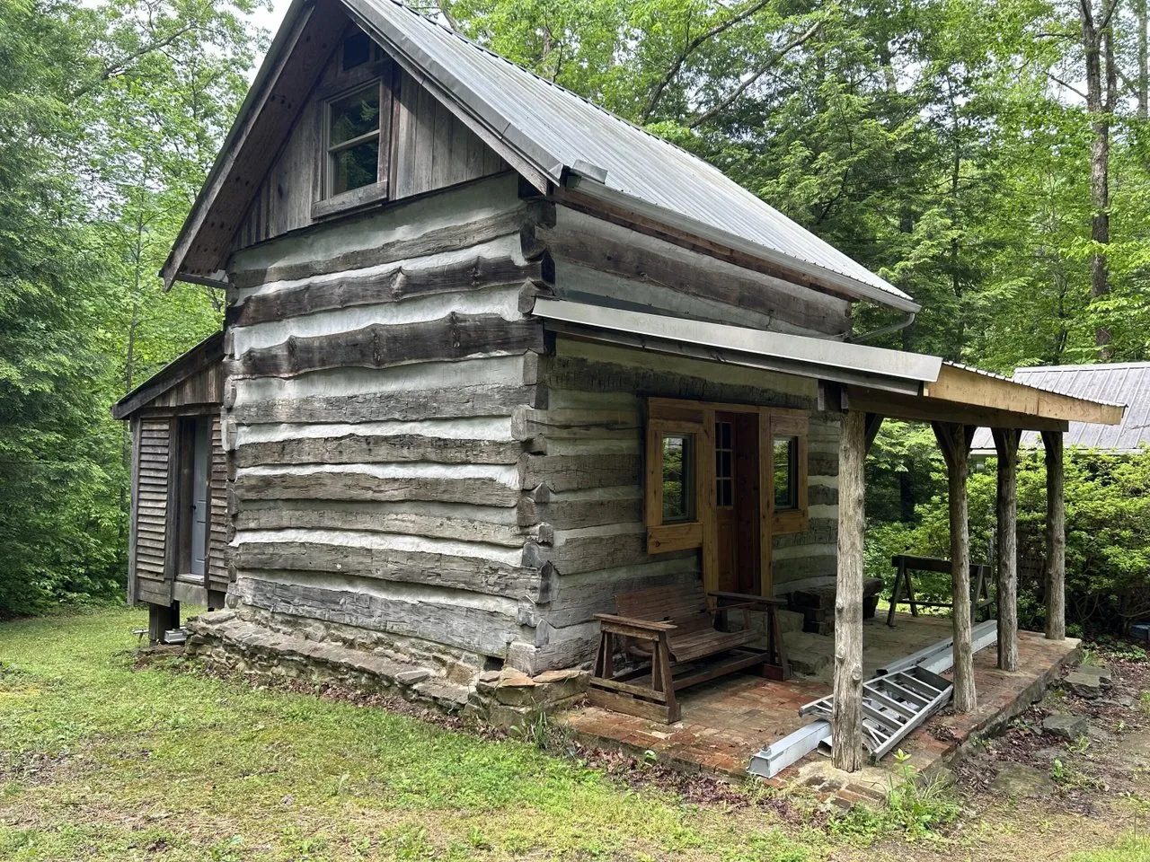 The hand-hewn log cabin with its chinked walls and a metal roof