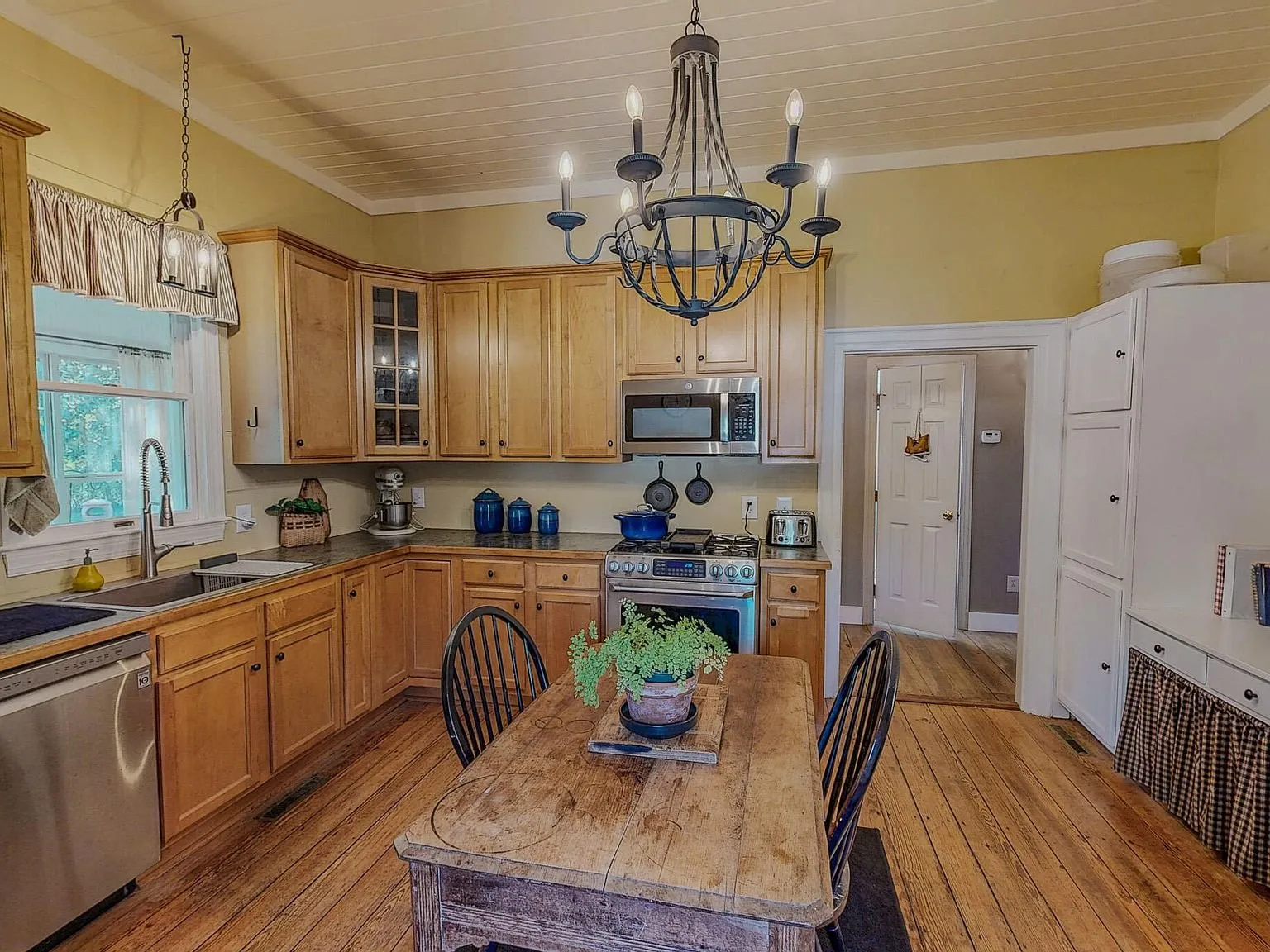 The kitchen with light wood cabinets, stainless appliances and a center island