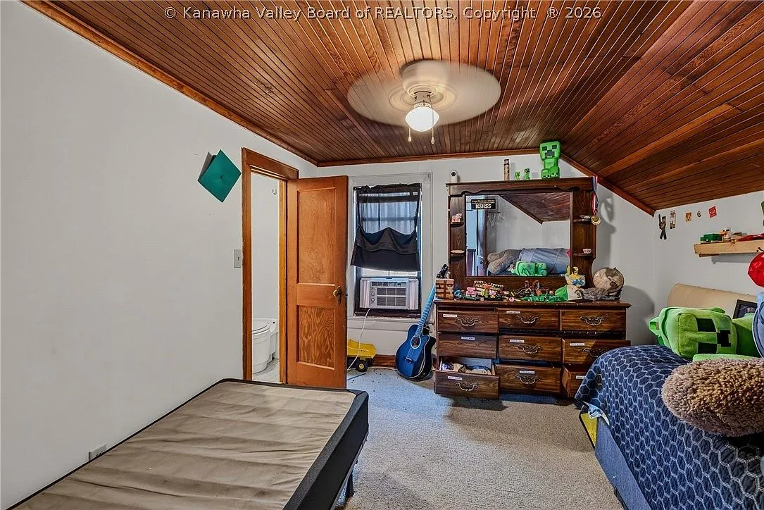 A kitchen nook with a gas range, white cabinets and a stainless refrigerator