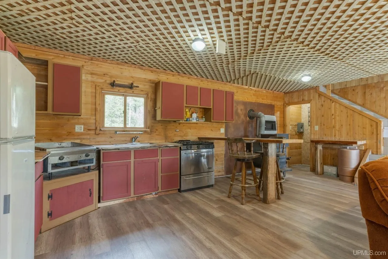 The kitchen with red cabinets, range and refrigerator