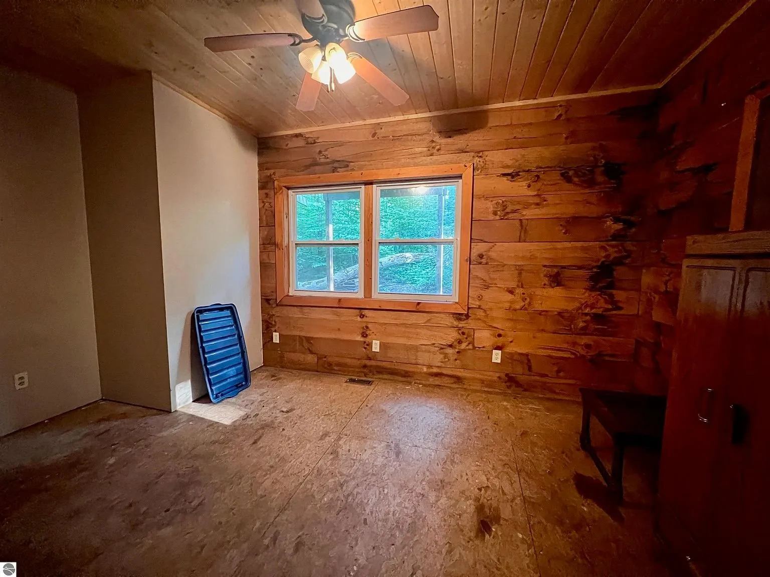 The main-level bedroom with the window and the log wall