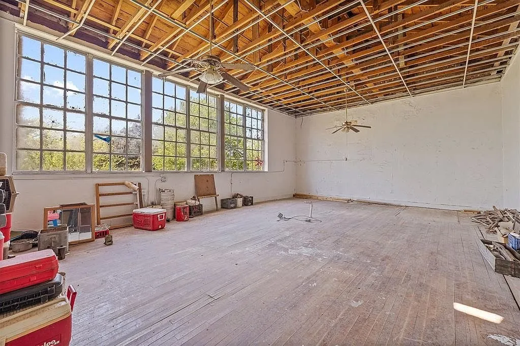 A classroom with the windows, the ceiling fan and the tools on the floor