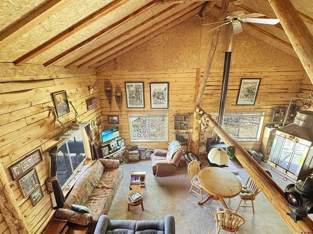 The living room from the loft with the ceiling fan and the windows