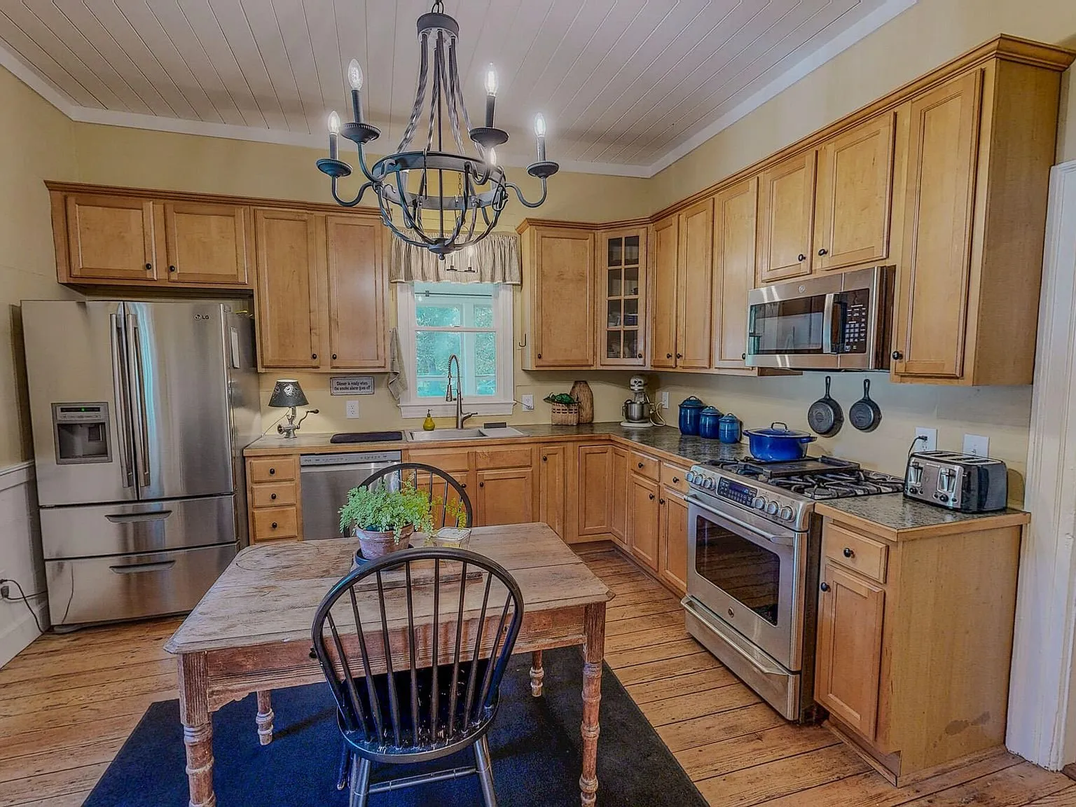 A second kitchen view with the range, microwave and prep table