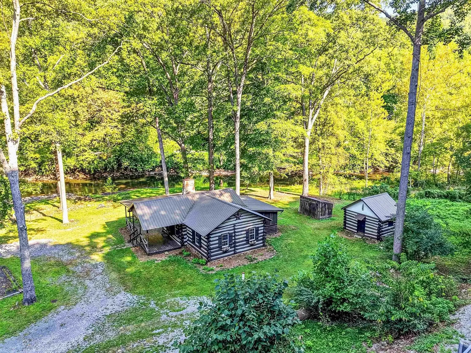 Aerial of the cabin and the outbuildings among the trees