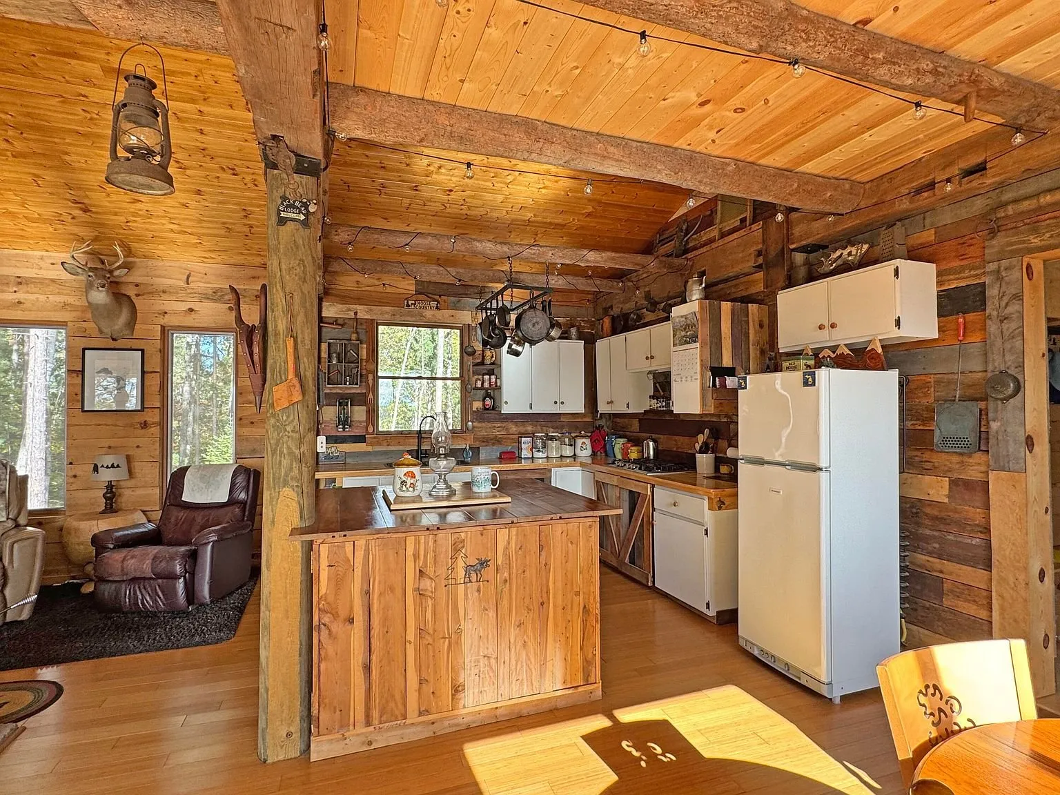 The kitchen from the living end, reclaimed wood cabinets and a white refrigerator