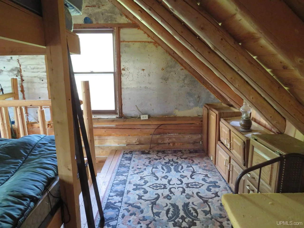 A window nook in the loft with a rug and a bench