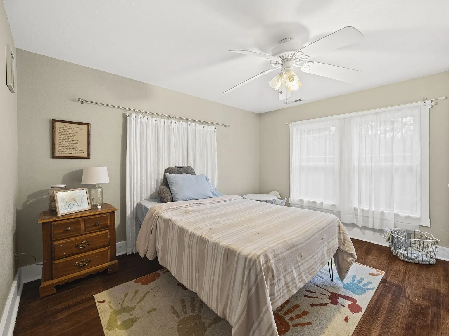 Second bedroom with wood floors and two windows