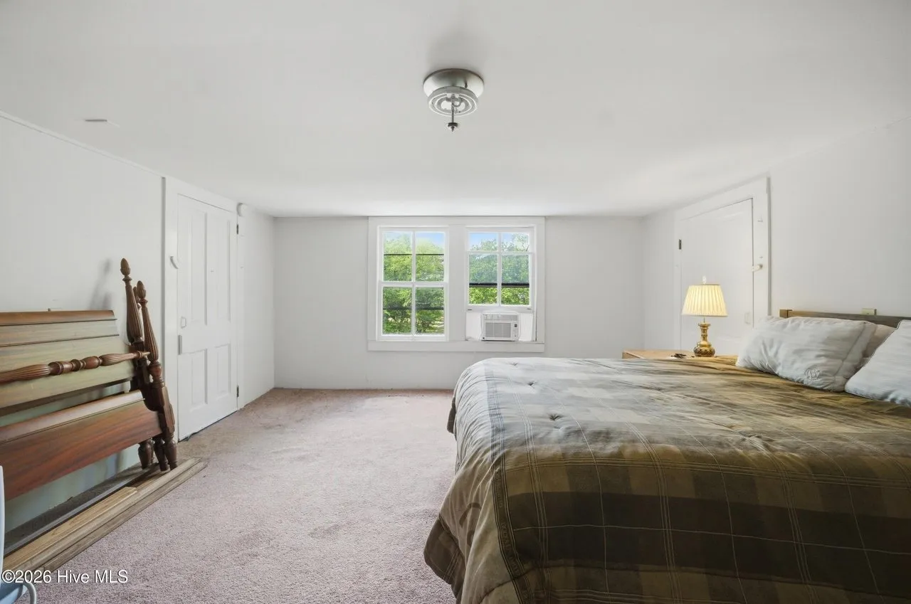 Bedroom with a window air-conditioning unit, carpeted