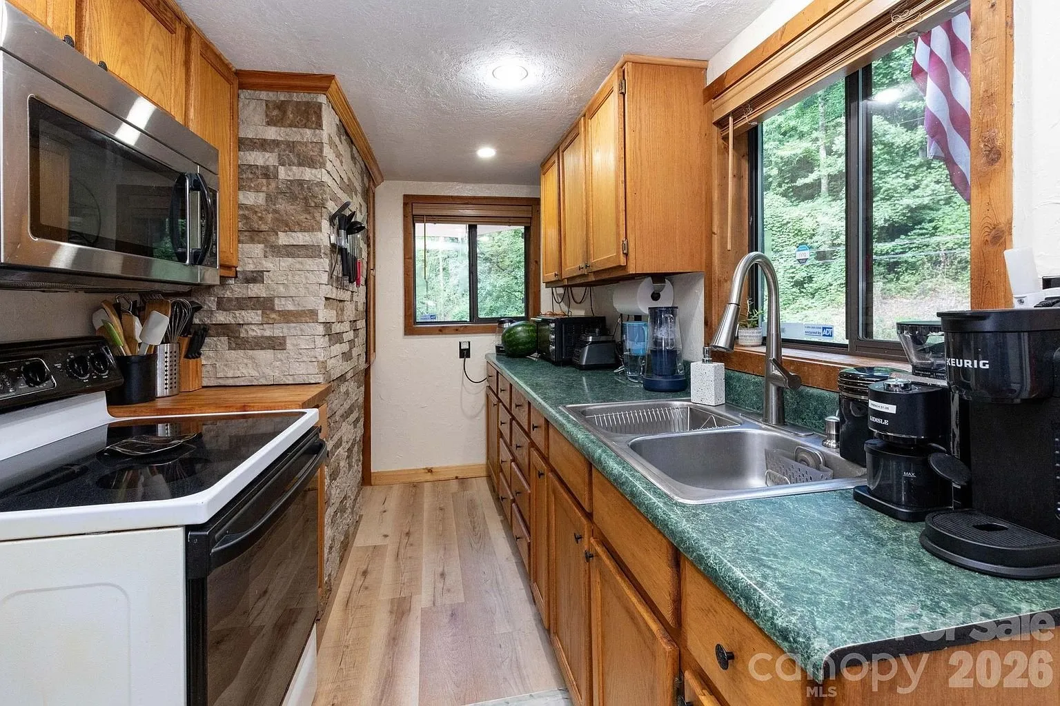 The kitchen with the green counters, the oak cabinets and the range