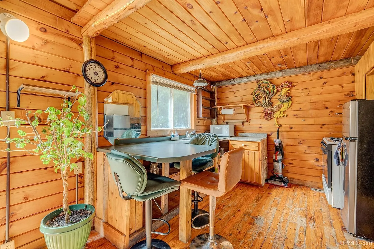 The kitchen and dining table under the peaked log ceiling