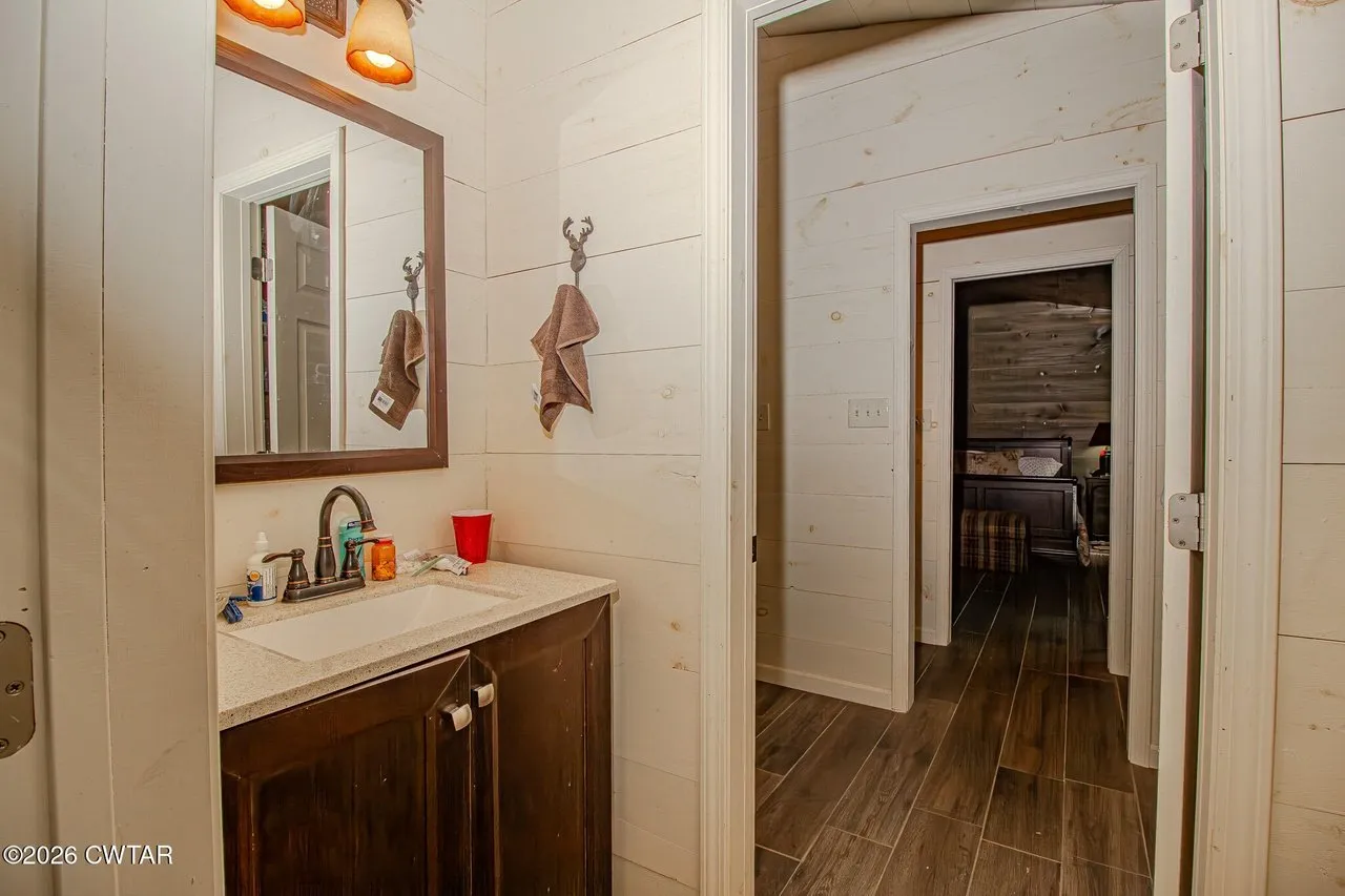 The second bath with a vanity and a doorway to the bedroom beyond