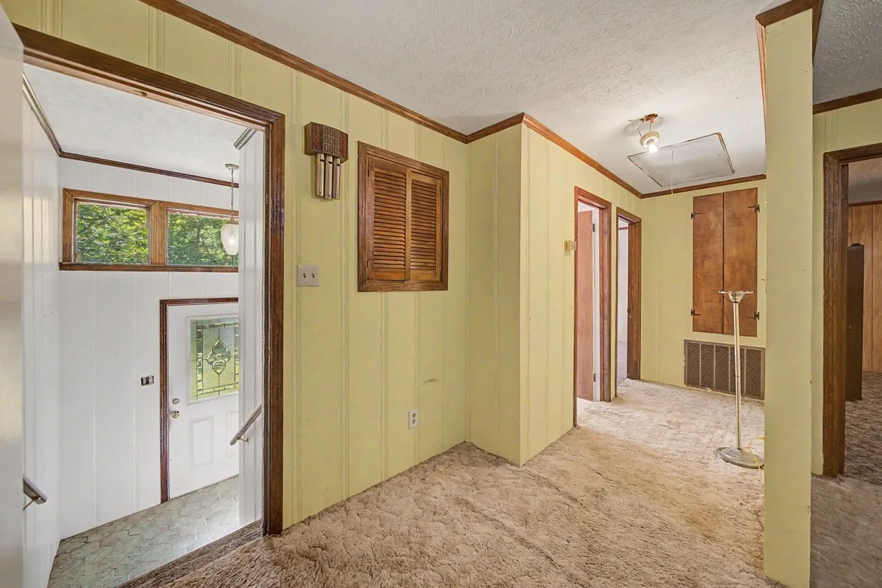 A hall with panelled walls and doors to several rooms