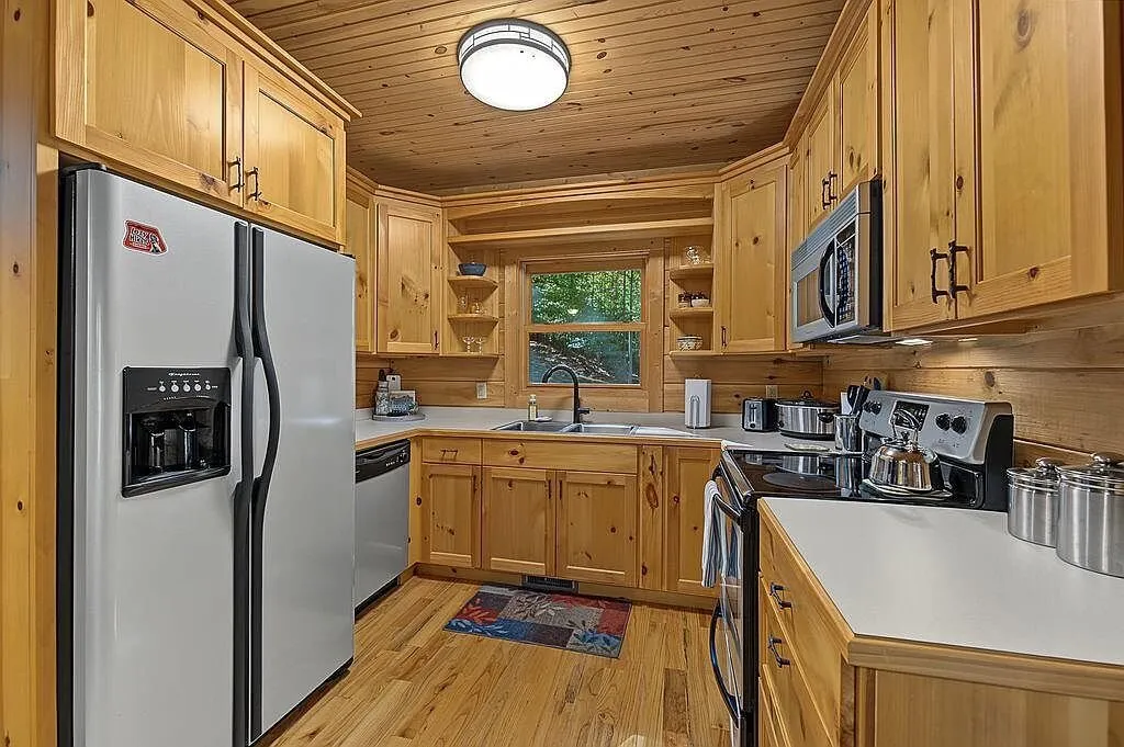 The refrigerator and cabinets along the kitchen's back wall