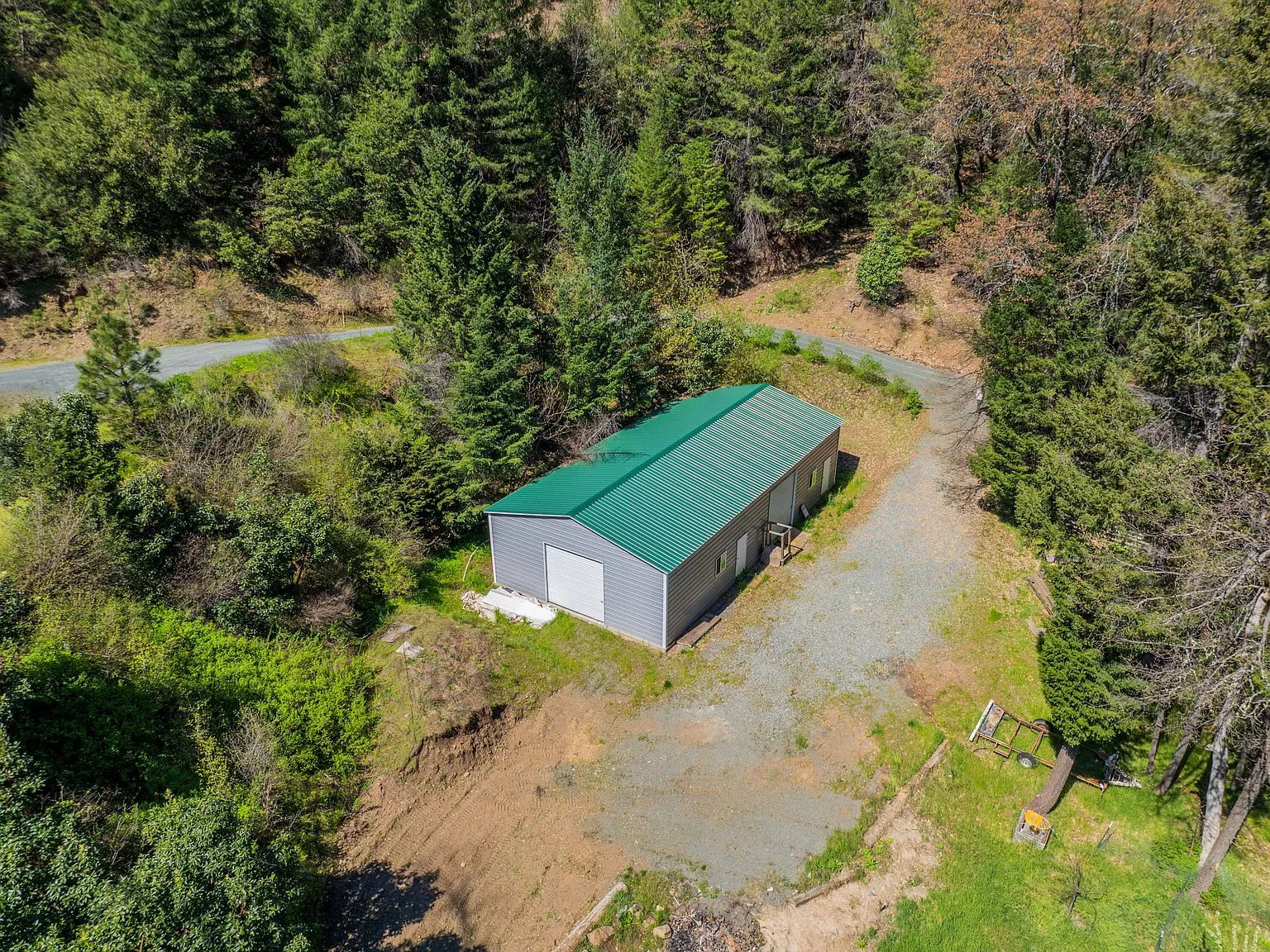An aerial view of the shop building and gravel driveway near the house
