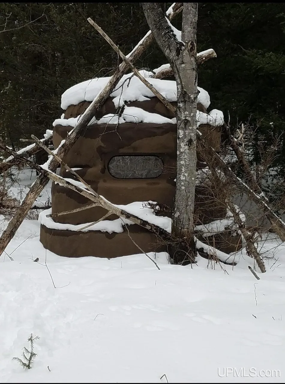 A wooden frame standing in the snow among the trees
