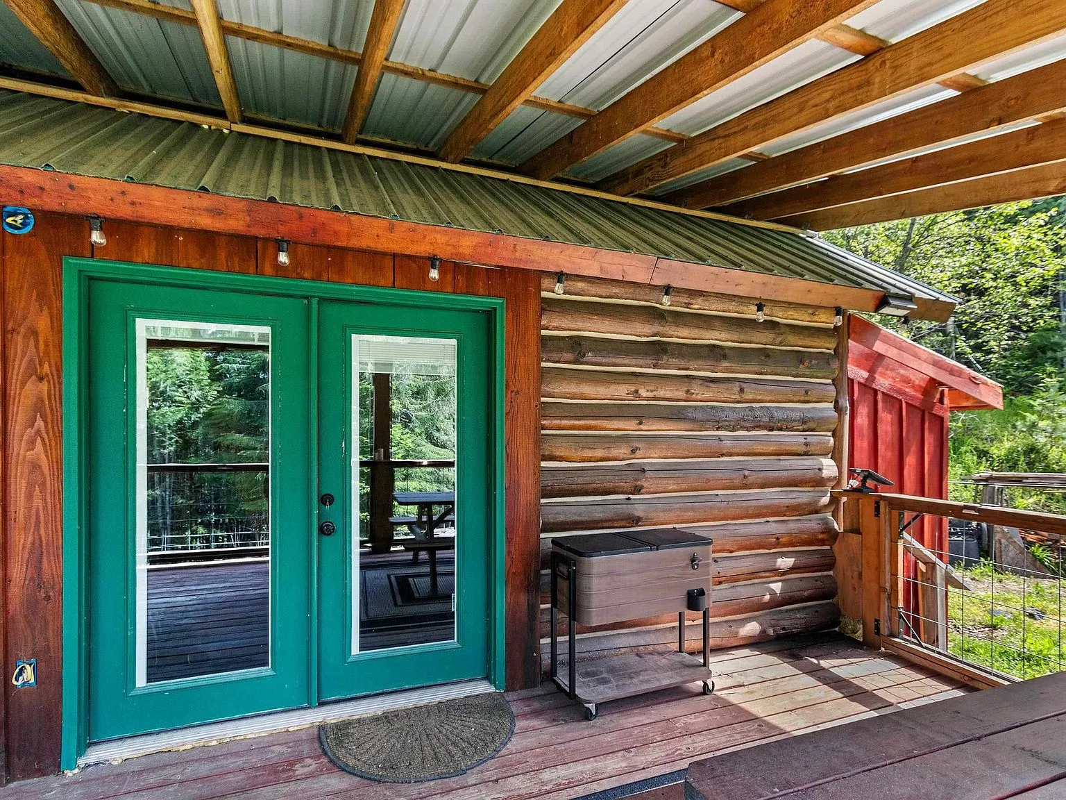 A second view of the green double doors opening onto the covered deck