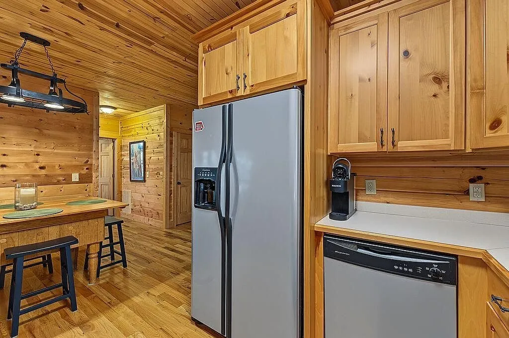 The kitchen counter with a coffee maker and stools at the bar