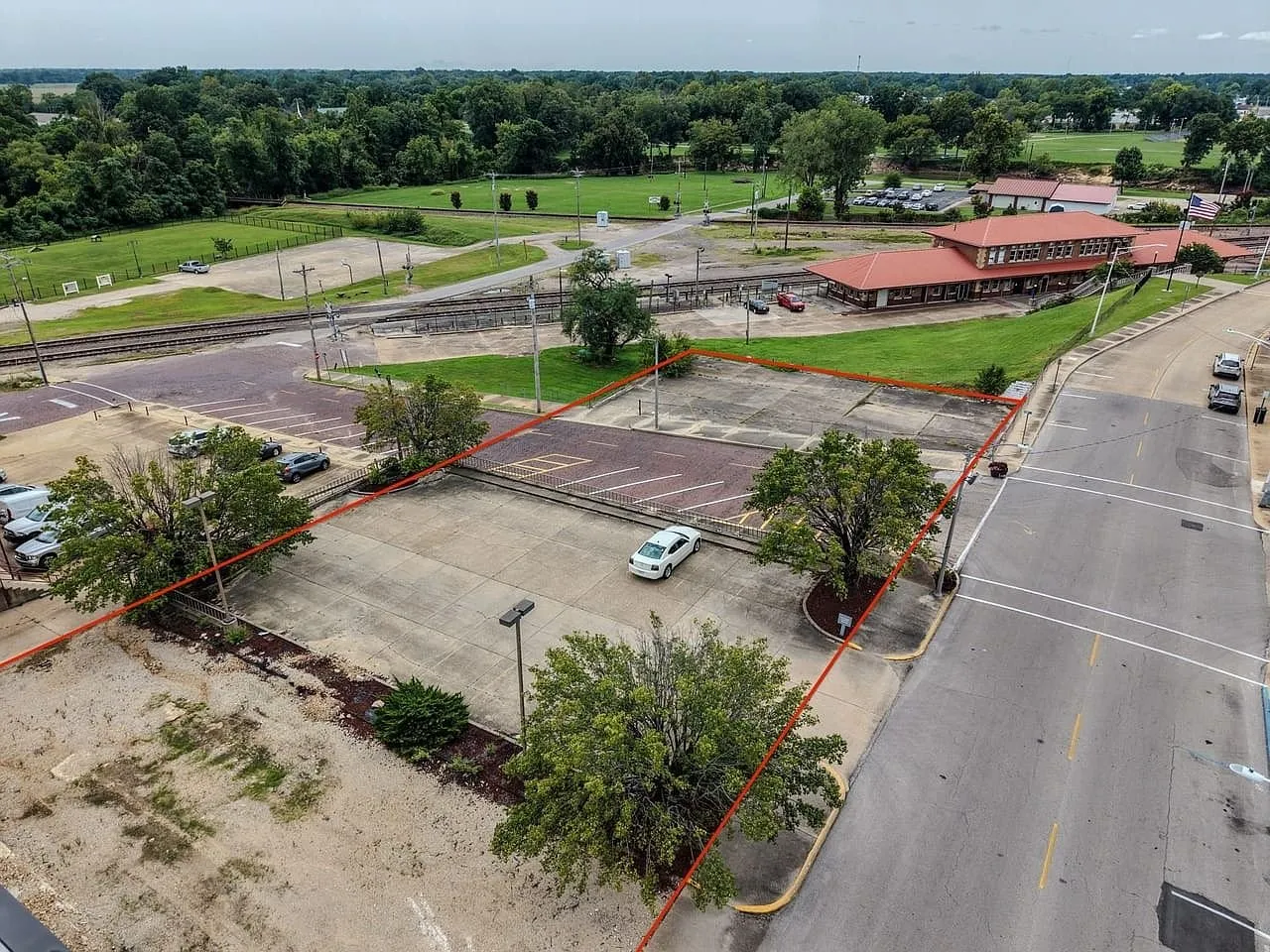 Aerial with the parking parcel outlined, the railroad crossing beside it