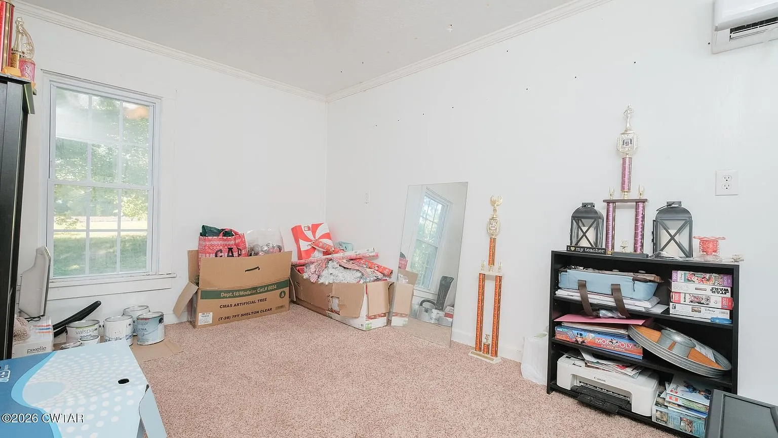 The room off the kitchen used for storage, with a window and shelving